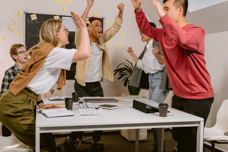 Uma imagem de uma equipe comemorando o sucesso após a conversão de leads em clientes.