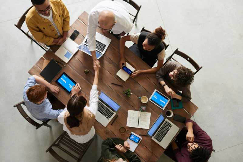 Uma imagem de um grupo de profissionais em uma reunião de tomada de decisões, com laptops e telas exibindo dados em tempo real, destacando como o BI em tempo real é usado na prática.